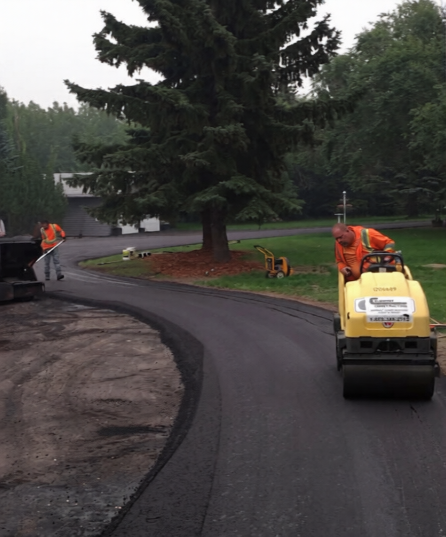 Covenant Construction crew laying asphalt with a roller on a Saskatchewan jobsite