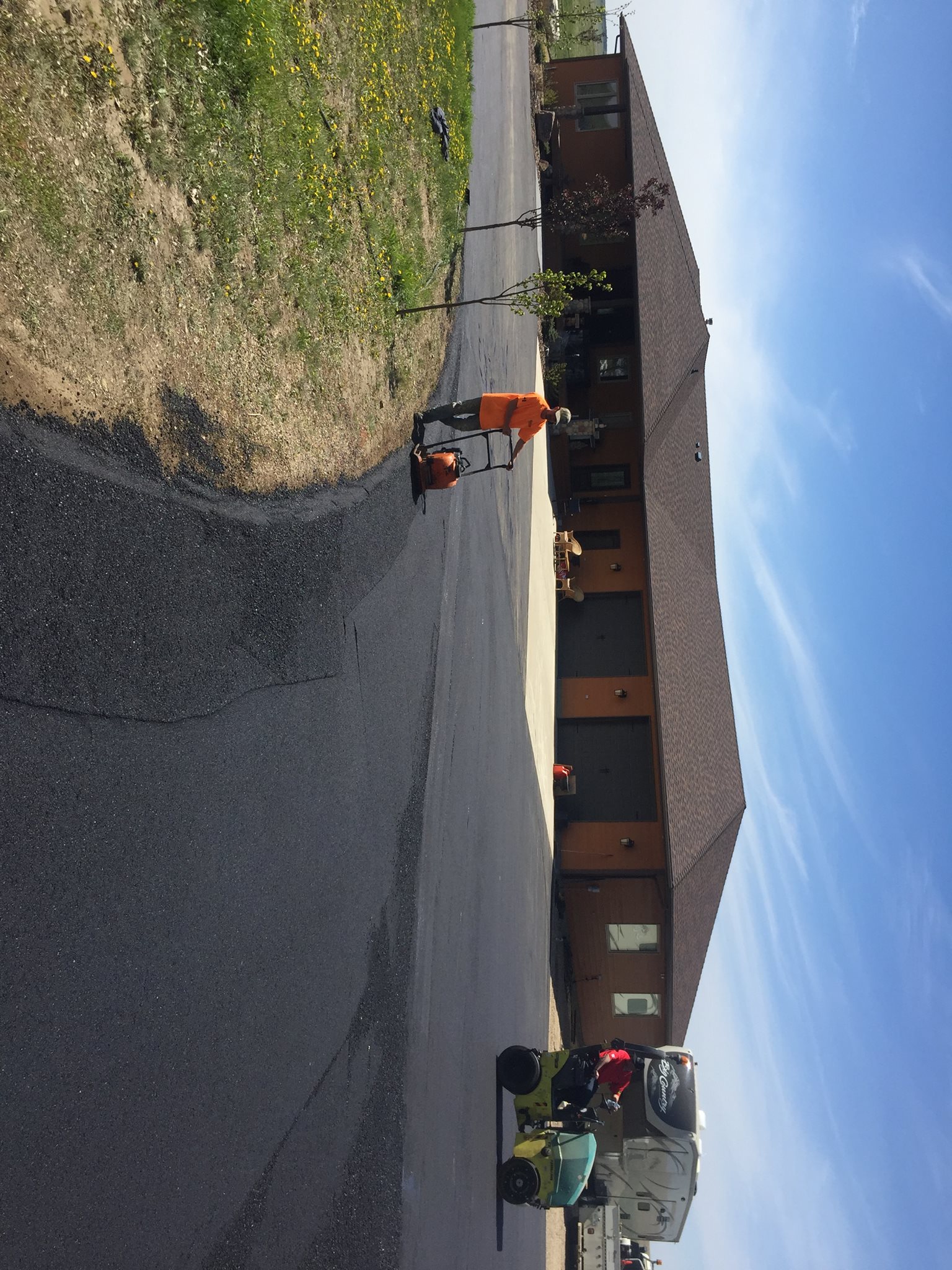 Covenant Construction crew compacting fresh hot-mix asphalt with a roller